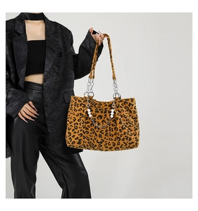 Detail of leopard print tote bag with metallic chain strap and pearl embellishment