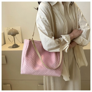 Close-up of pink woven texture on a large tote bag with cream shoulder straps