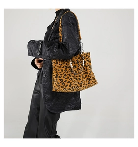 Detail of leopard print tote bag with corduroy texture and pearl chain strap on model