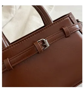 Close-up of dark brown lychee texture leather with silver metal buckle detail