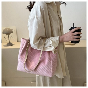 Close-up of pink woven texture tote bag with slim shoulder strap and stylish grid pattern