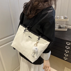 Off-white nylon tote bag with black leather trim and cute furry monster pendant charm