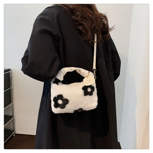Détail du sac à main blanc en peluche avec motif floral noir et bandoulière élégante
