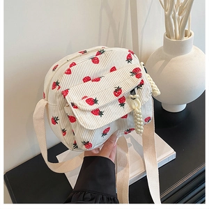 Close-up of beige corduroy strawberry print crossbody bag with front flap pocket