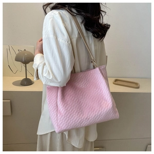 Detail of pink woven tote bag with slim leather straps and metallic ring connectors