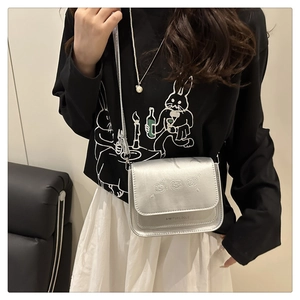 Détails du sac à bandoulière argenté métallisé avec motif ours gaufré et fine chaîne