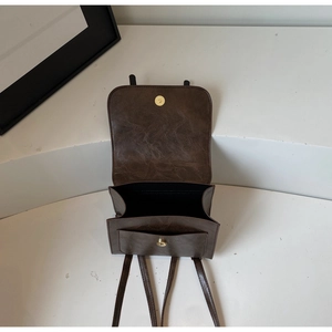 Detail view of the deep brown vintage backpack with magnetic snaps and interior pockets