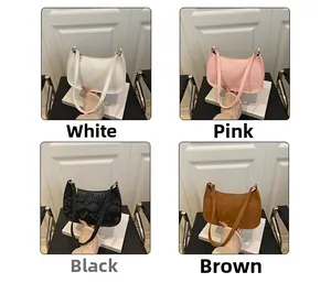 Detail view of crescent baguette bags in white, pink, black, and brown textured leather