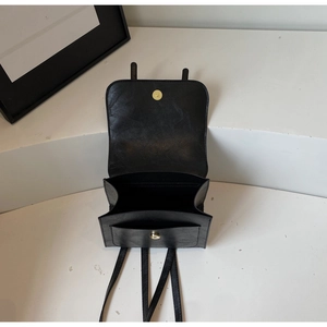 Close-up of a vintage black backpack showing dual compartments and gold magnetic buckle