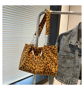 Detail of leopard print corduroy tote bag with silver chain and pearl decoration