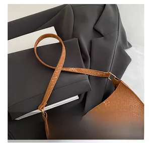 Macro view of caramel brown snakeskin embossed texture on stylish baguette bag