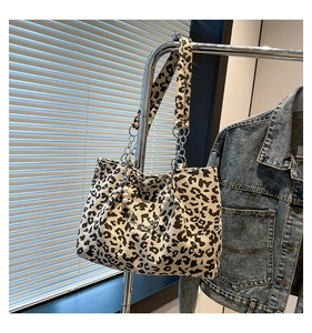 Detailed texture of leopard print tote bag with pearl and chain shoulder strap detail