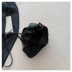 Détail d'un sac à bandoulière en fausse fourrure noire avec garniture en cuir PU et chaîne