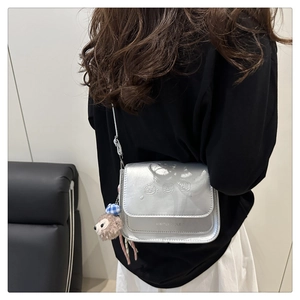 Détail du sac bandoulière argenté avec ours gaufrés et pendentif en peluche