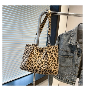 Detail of leopard print corduroy tote bag with decorative pearls and metal chains