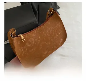 Close-up of caramel faux snake skin texture and gold hardware on hobo shoulder bag