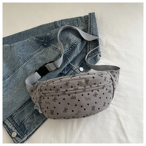 Detalle de riñonera de pana gris con estampado dulce sobre un fondo de tela denim