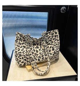 Detail of leopard print corduroy tote bag with silver chain and pearl ornaments