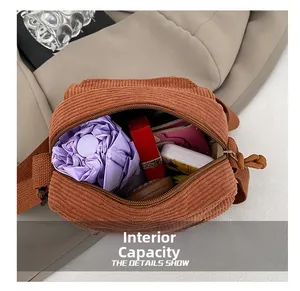 Macro view of corduroy crossbody bag interior showing spacious storage and top zipper