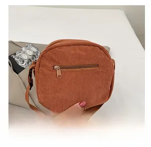 Detail of caramel corduroy crossbody bag with front anti-theft zipper and striped texture