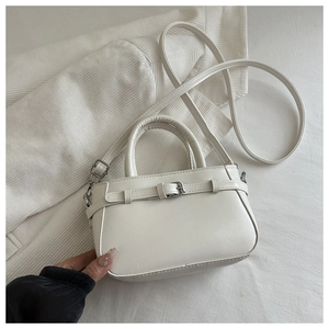 Détail du sac bandoulière blanc cassé en similicuir avec boucle argentée et grain fin
