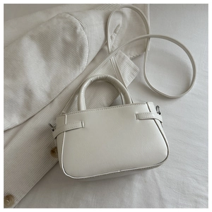 Detailed view of cream PU leather handbag with pebble grain texture and sleek handle