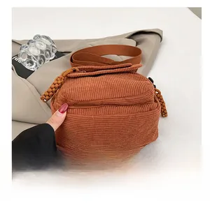 Detail shot of a brown corduroy crossbody bag with durable wear-resistant bottom base