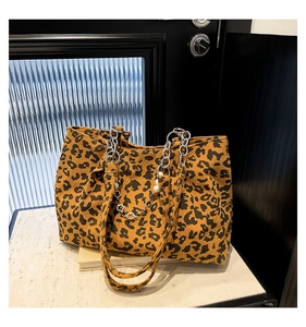 Macro detail of leopard print tote bag corduroy texture with pearl and chain charm