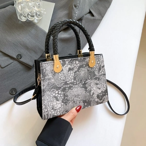 Chic black and white jacquard handbag with black woven handles and gold hardware accents