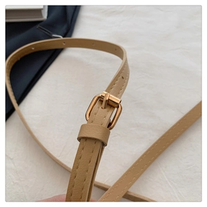 Détail de la bandoulière réglable en similicuir beige avec boucle dorée en métal