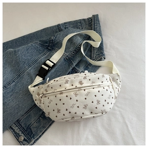 Detalle de riñonera de pana blanca con estampado de corazones y mariposas marrones