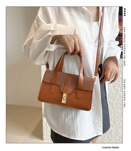 Détail du sac à main rétro avec mélange de textures et fermoir doré sur le rabat
