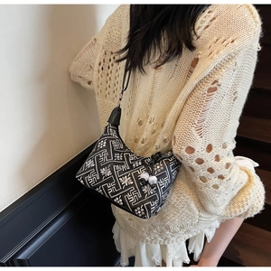 Detail of ethnic floral embroidery and bead drawstring on black dumpling shoulder bag
