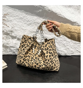 Close-up of leopard print tote bag with corduroy texture, pearl chain, and silver metal links