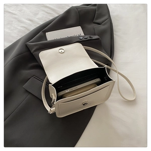 Vue intérieure montrant la capacité du sac bandoulière crème avec téléphone et portefeuille