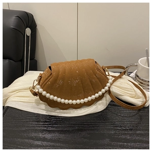 Macro view of brown snakeskin shell bag featuring decorative pearls and golden hardware
