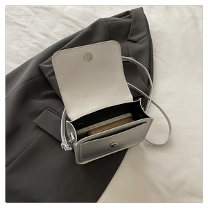 Vue intérieure d'un petit sac argenté contenant un téléphone et un portefeuille