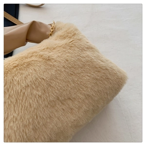 Detail shot of the plush cream faux fur texture with elegant gold chain and leather strap