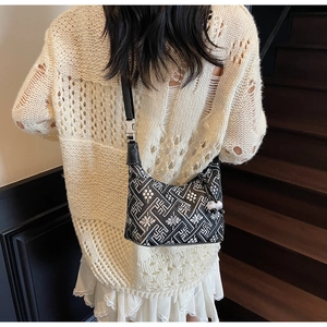 Close-up of black and white geometric jacquard pattern on shoulder bag with leather strap