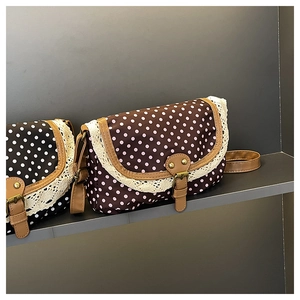 Close-up of retro polka dot canvas bags with delicate lace trim and leather straps