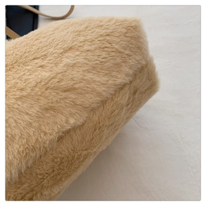 Close-up of soft beige plush faux fur texture with navy blue leather strap detail