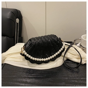 Detail of shell-shaped crossbody bag with pearl strap and snake-embossed black leather