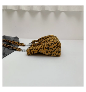 Detail of leopard print corduroy tote featuring pearl buckle and metal chain strap