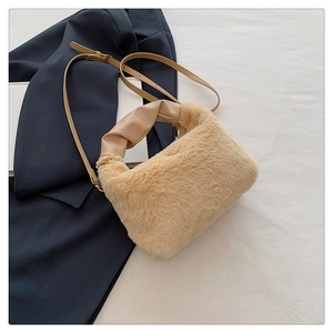 Detail of plush faux fur handbag with stylish knotted synthetic leather handle and strap