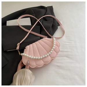 Detailed view of pink shell bag with snake texture, pearl handle and gold hardware