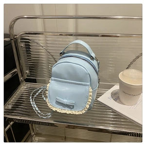 Detail eines hellblauen Mini-Rucksacks aus PU-Leder mit Spitzenbesatz und niedlicher Schleife
