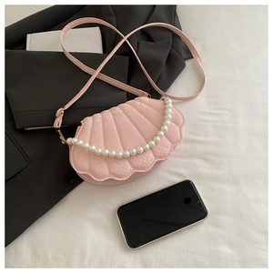 Detailed view of pink seashell crossbody bag with snakeskin texture and pearl handle