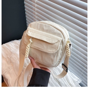 Détail du sac bandoulière en velours côtelé crème avec détails tressés et sangle