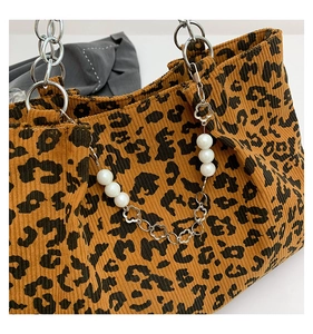 Detail of leopard print corduroy tote bag featuring pearl and silver flower chain decoration