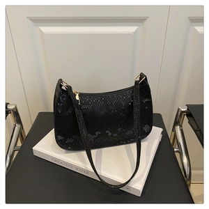 Detail shot of the black python texture finish and golden hardware on this baguette bag